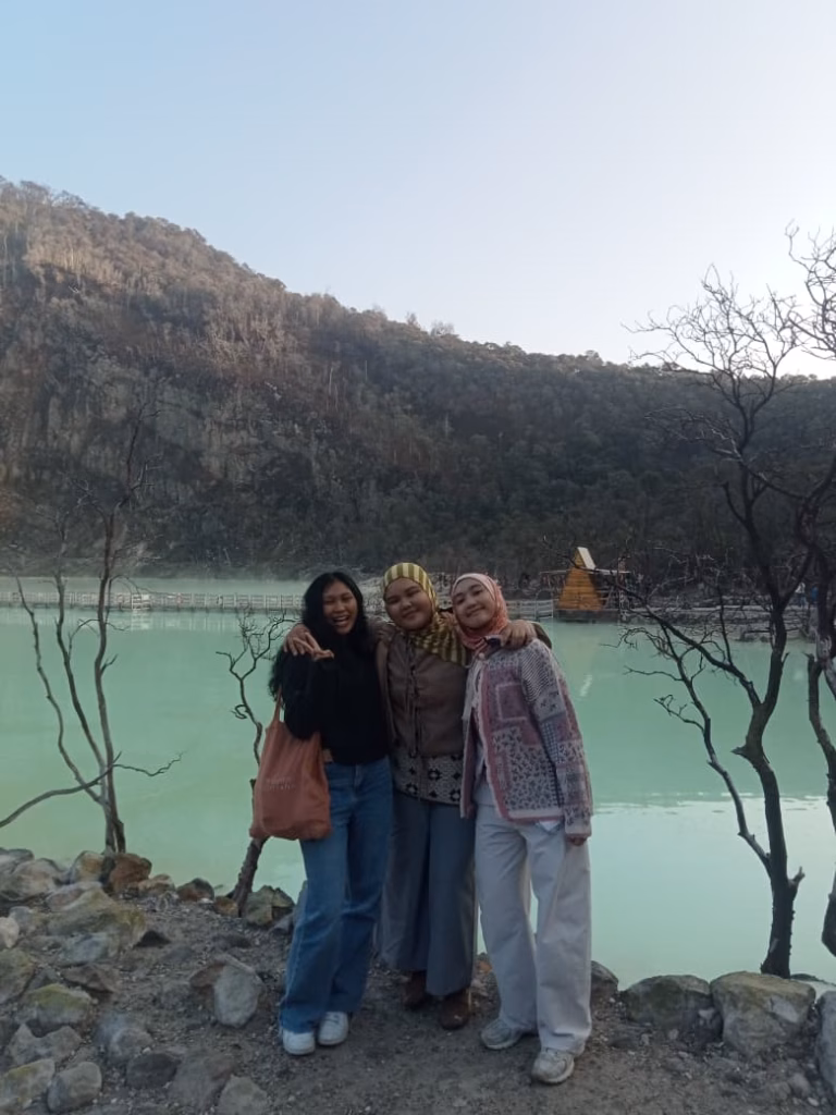 Three travelers posing at Kawah Putih Ciwidey after sunrise in the Bandung highlands